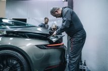 man working on damaged car in garage