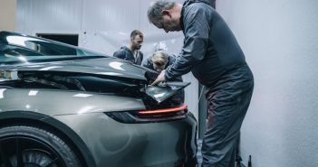 man working on damaged car in garage