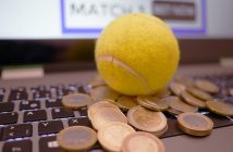 tennis ball and coins on laptop keyboard