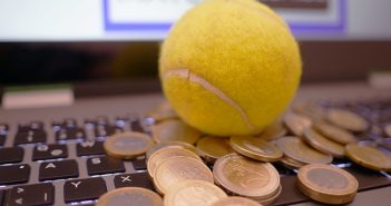 tennis ball and coins on laptop keyboard