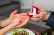 close-up of man giving woman engagement ring in red box