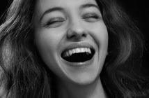 pretty woman with nice teeth close-up with closed eyes and open smile