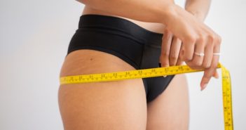 close-up of attractive women in black panties measuring her waist