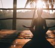 rear silhouette view of woman doing yoga at sunrise