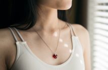close-up of necklace on beautiful brunette woman in off white top