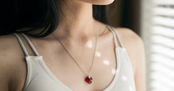 close-up of necklace on beautiful brunette woman in off white top