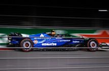 blue purple formula one race car going around track