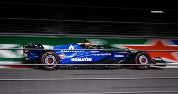 blue purple formula one race car going around track