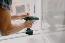 close-up of workman hands holding electric drill