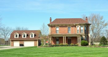 large house with green lawn and driveway