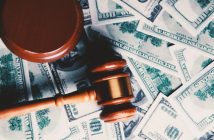 wooden gavel on top of paper money