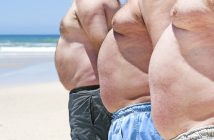 three shirtless men with bellies on the beach