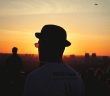 silhouette of man in hat with sunset in background