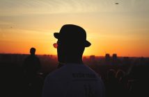 silhouette of man in hat with sunset in background