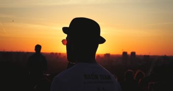silhouette of man in hat with sunset in background