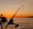 fishing line with water and sunset in background