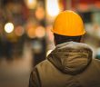 rear view of worker in yellow hardhat and jacket