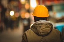 rear view of worker in yellow hardhat and jacket
