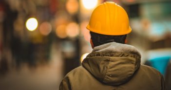 rear view of worker in yellow hardhat and jacket