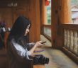 side view of pretty chinese woman holding phone