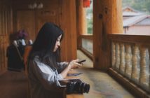 side view of pretty chinese woman holding phone