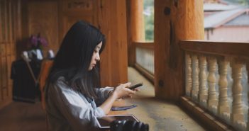 side view of pretty chinese woman holding phone