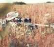 hunter with rifle in weeds
