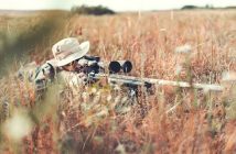 hunter with rifle in weeds