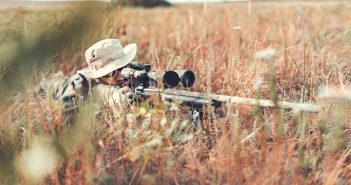 hunter with rifle in weeds