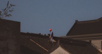 construction worker with red hardhat on roof