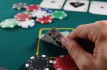 cloesup of hand of two kings on table with chips for poker