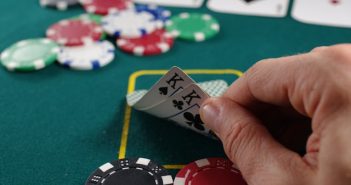 cloesup of hand of two kings on table with chips for poker