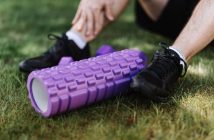close-up of man's sneekers in grass next to roller