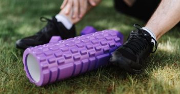 close-up of man's sneekers in grass next to roller