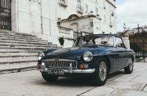 classic car next to stairs of old stone building