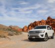 white Ford SUV on dirt road