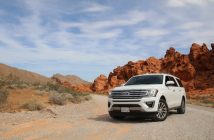 white Ford SUV on dirt road