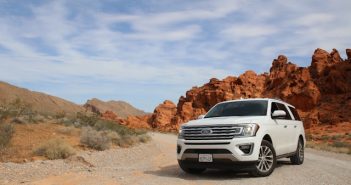 white Ford SUV on dirt road