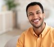 man in tellow shirt smiling with nice white teeth
