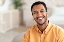 man in tellow shirt smiling with nice white teeth