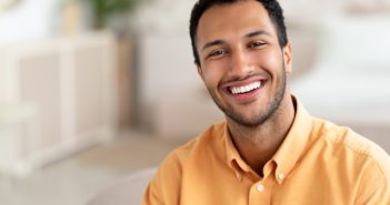 man in tellow shirt smiling with nice white teeth