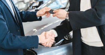 handing over car keys and shaking hands