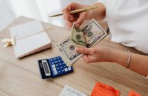 close-up of woman's hands holding money over desk