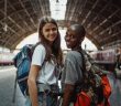 two pretty female travelers in train station