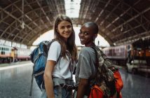 two pretty female travelers in train station