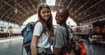 two pretty female travelers in train station