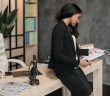 female lawyer in dark suit sitting on desk looking over papers