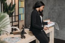 female lawyer in dark suit sitting on desk looking over papers