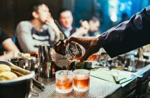 close-up of bartender hand pouring a cocktail