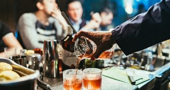 close-up of bartender hand pouring a cocktail